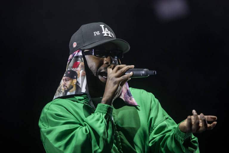 Cantor de boné verde em performance ao vivo.