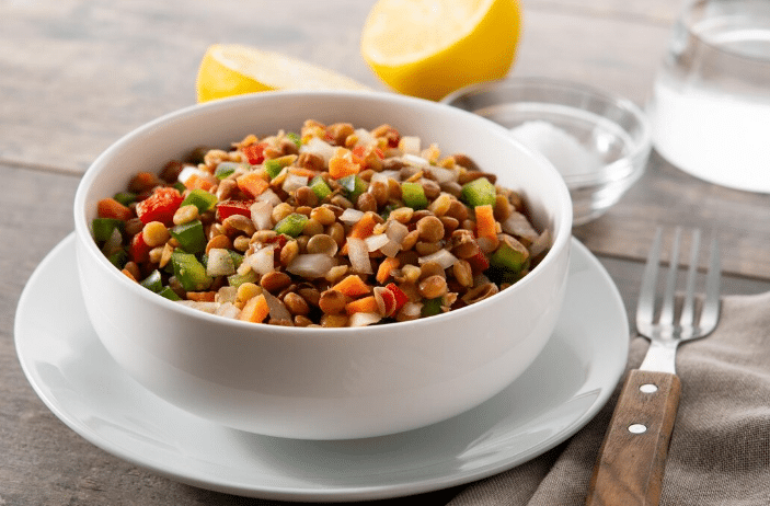 Tigela com salada de lentilha, cenoura e pimentão.