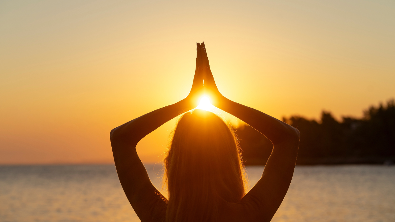 Imagem de uma mulher saudando o Sol